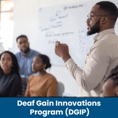 A man in white shirt delivers a presentation to a captivated group of listeners in a conference setting.